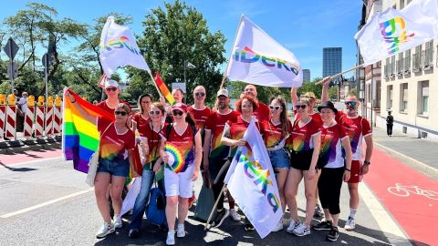 Mitarbeiterinnen und Mitarbeiter der Deka mit bunten T-Shirts und Regenbogenflagge