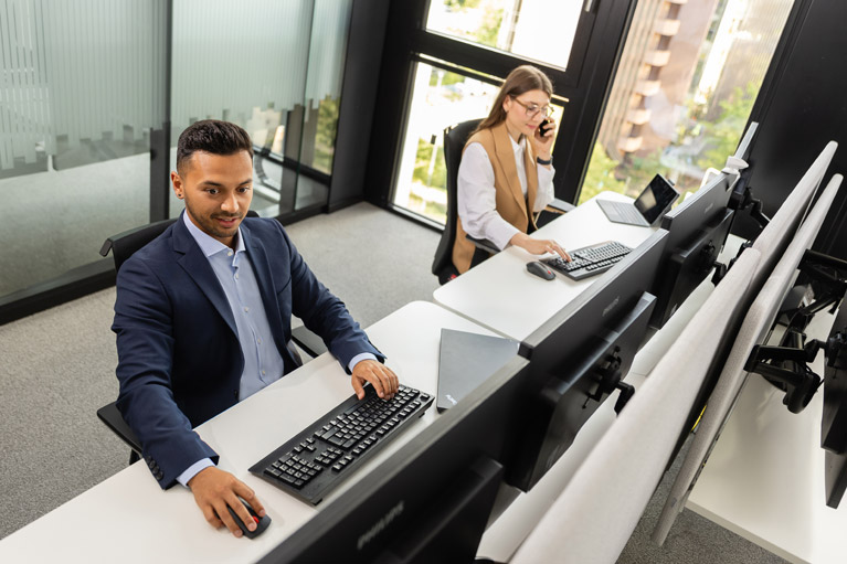 Two Deka employees in front of their computers